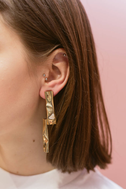 earrings on the ears hang. Stylish earrings with shells - 写真・画像