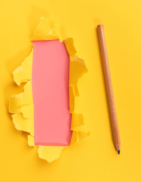 Yellow torned paper over pink background with pencil - Foto, Bild