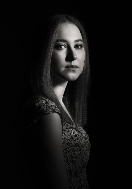Dramatic Portrait of a young woman on a black background - Foto, imagen