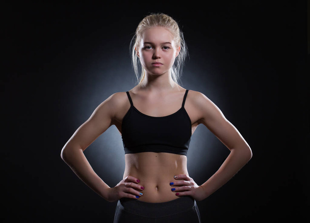 Female athlete on dark background. - Photo, Image