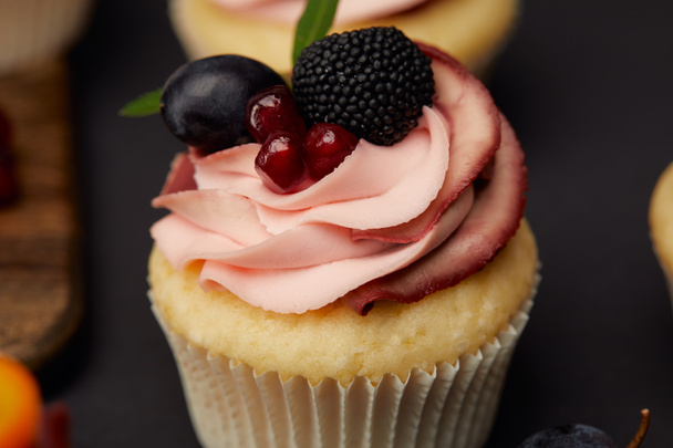 sweet cupcake with cream, garnet, blackberry and grape  - Фото, зображення