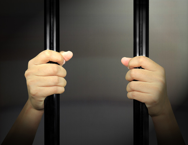 Мужские руки заключенного на стальной решетке
 - Фото, изображение