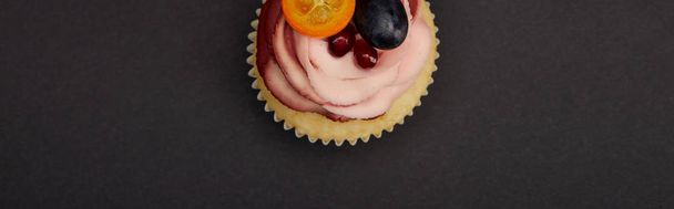 黒い表面にクリームとフルーツとカップケーキのパノラマショット - 写真・画像
