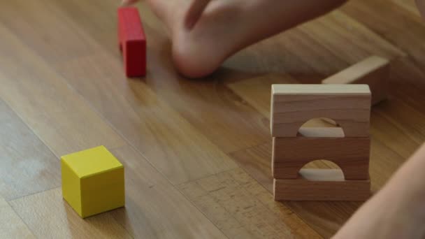 3 years old child boy play with wooden blocks, build house at home. - Footage, Video