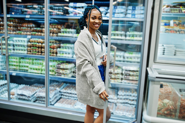 African american woman near refrigerator shelf selling dairy pro - Valokuva, kuva