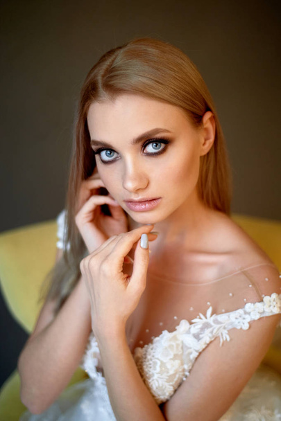 Portrait of a beautiful bride in a lace dress.Makeup smoky eyes, emphasis on eyes. Long flowing hair. - Photo, image