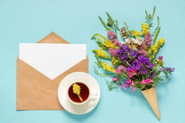 Field flowers, craft envelope and cup of herbs tea - Foto, Bild