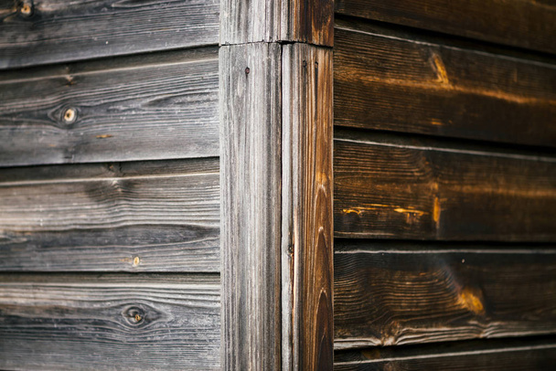 Angle of wall of rural house from horizontal planked wood. Detail fragment of vintage natural wooden texture with copy space. Natural structure of woods. Background from edge of uneven wooden wall. - Foto, imagen