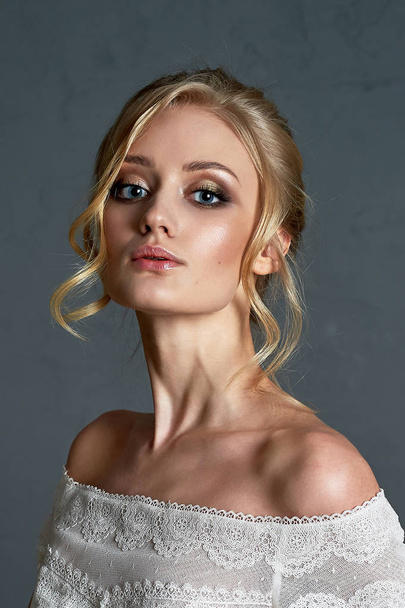 Portrait of a beautiful miniature bride in a lace dress. Hair with curls. Emphasis in make-up on the eyes.Blonde. - Zdjęcie, obraz