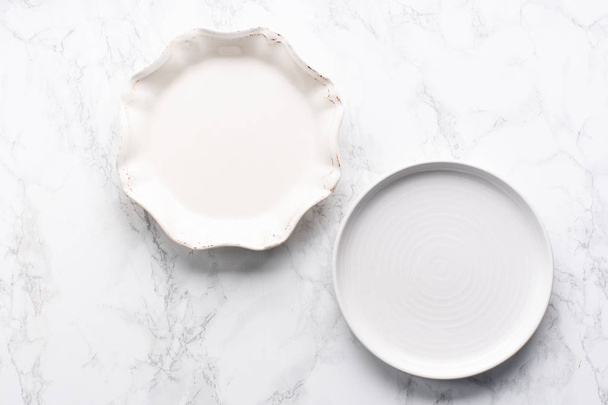 beautiful white porcelain plates on marble surface, top view  - Fotó, kép