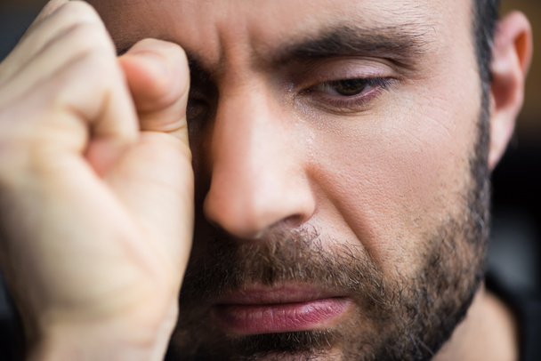 portrait of handsome crying man wiping tears away with hand - Photo, Image