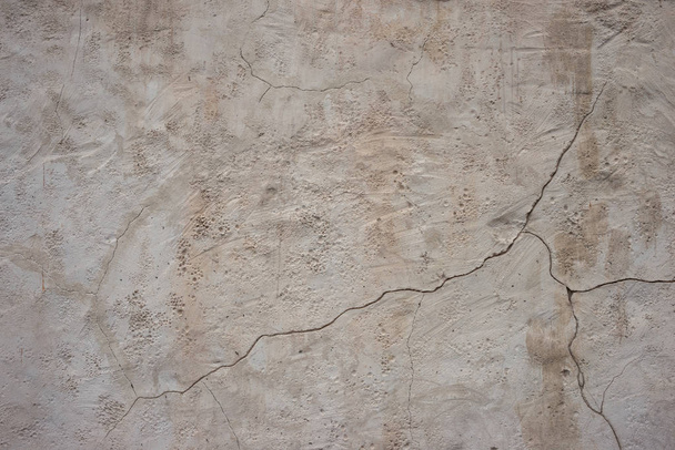 石膏に亀裂を持つ古い粗い灰色の壁。構造化グランジ  - 写真・画像