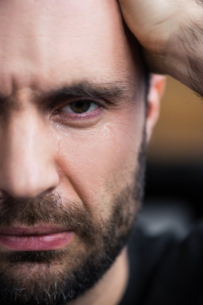 partial view of depressed bearded man crying and looking at camera - Photo, Image