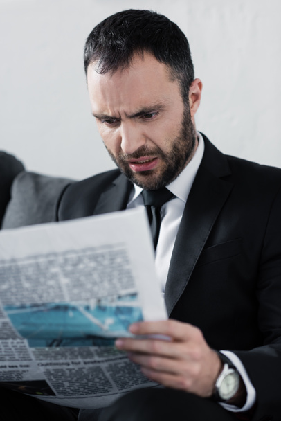 enfoque selectivo del impactado empresario barbudo leyendo el periódico
 - Foto, Imagen