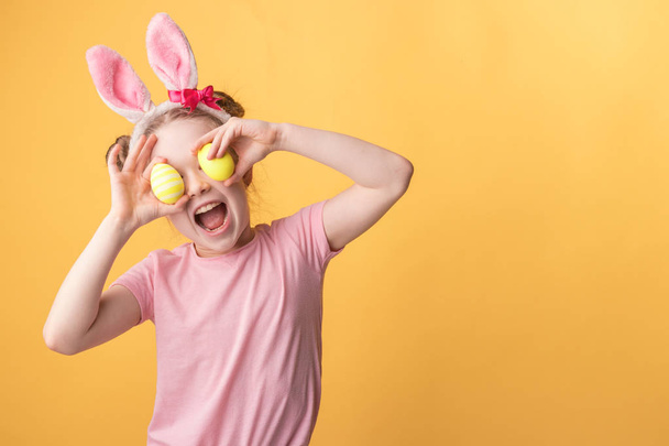 girl with bunny ears holds painted Easter eggs  - Φωτογραφία, εικόνα