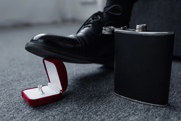 partial view of man trampling gift box with ring near flask on floor - Foto, immagini