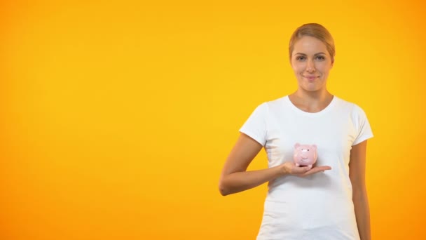 Happy female covering piggybank by hand, safe bank deposit, account insurance - Filmagem, Vídeo