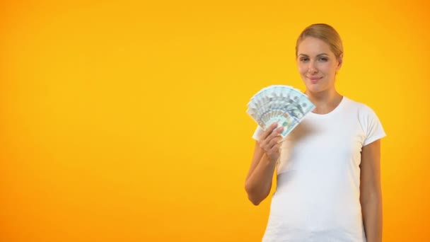 Pretty smiling woman showing thumbs up holding dollars, cashback service, credit - Video, Çekim