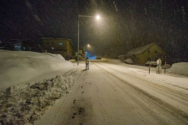 Person an verschneiter Straße nachts beleuchtet - Foto, Bild