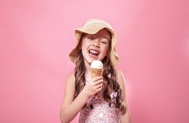 Portrait of a little cheerful girl with ice cream on a colored background - Zdjęcie, obraz