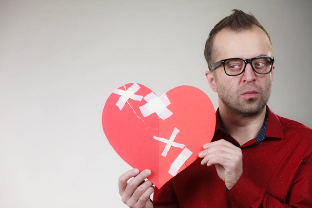 Thoughtful man holds broken heart - Fotografie, Obrázek