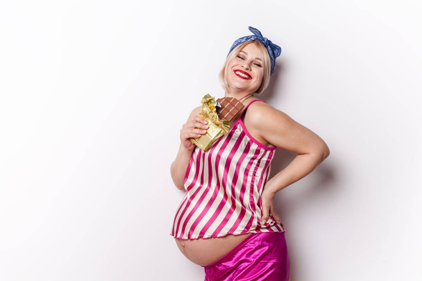 Pregnant adult woman enjoying of eating chocolate bar, copy spac - Foto, Bild