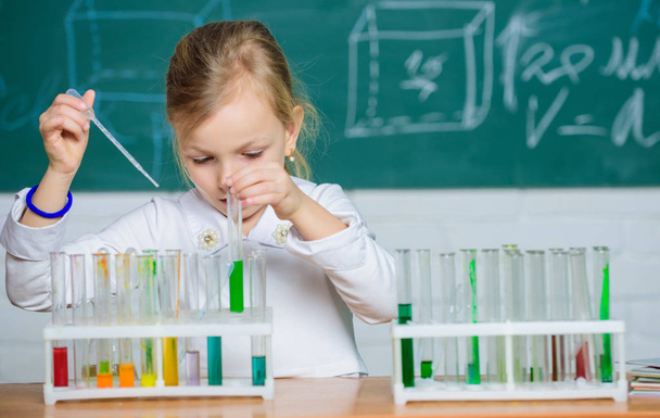 Interesting approach to learn. Future scientist. Explore and investigate. School lesson. Girl cute school pupil play with test tubes and colorful liquids. School chemical experiment. School education - Фото, зображення