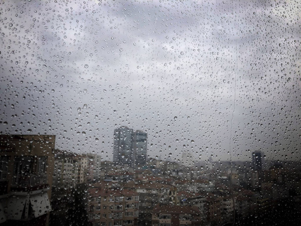 Regentropfen auf Fenster gegen Stadtblick - Foto, Bild