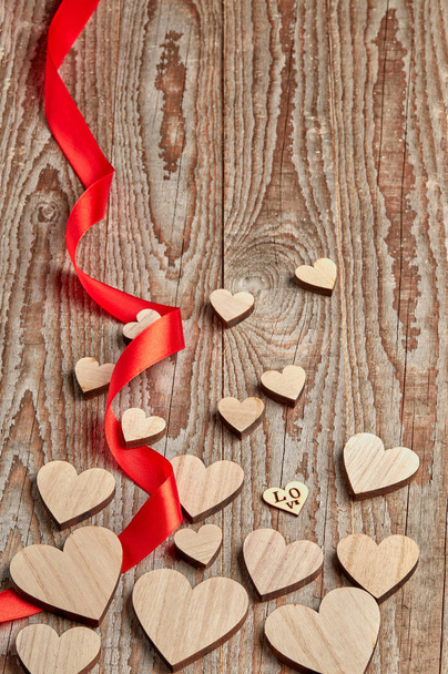 Różne wielkości serca i czerwona wstążka na drewnianym tle  - Zdjęcie, obraz