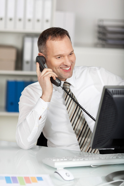 Calling businessman in office - Foto, Bild