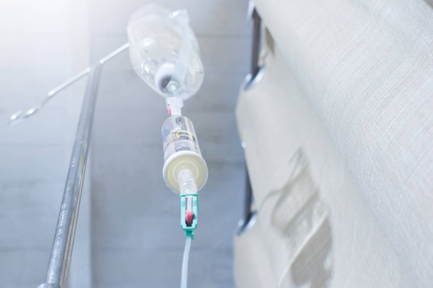 iv solution infusion, bottom view of saline bottle from the eyes of the patient on bed in the patient room - Foto, afbeelding