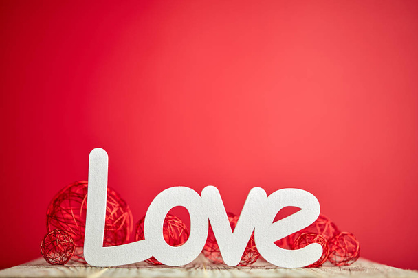 Bílá značka lásky na dřevěném stole a červené pozadí  - Fotografie, Obrázek