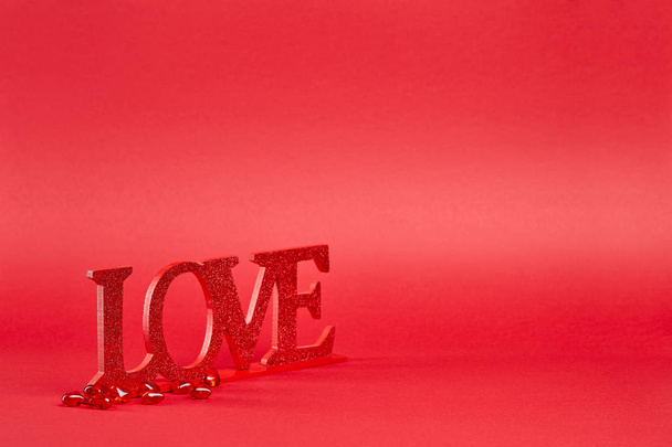 Червоний фон з великим блискучим знаком любові і кришталевими серцями конфетті
 - Фото, зображення