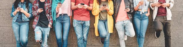 屋外でスマートモバイルスマートフォンを使用する友人のグループ - 新しい技術トレンドアプリに中毒ミレニアル世代の若者 - 人、技術、ソーシャルメディア、世代zと若者のライフスタイルの概念 - 写真・画像