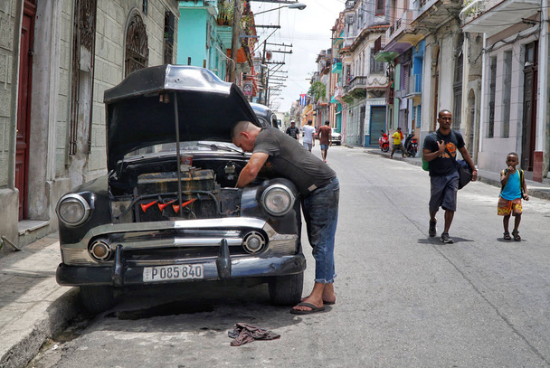 Гавна, Куба-30 квітня, 2017; Чоловік Ремонтне свій автомобіль на вулиці  - Фото, зображення