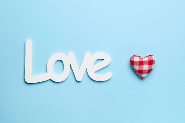 Plain blue background with red heart and white love sign - Photo, Image