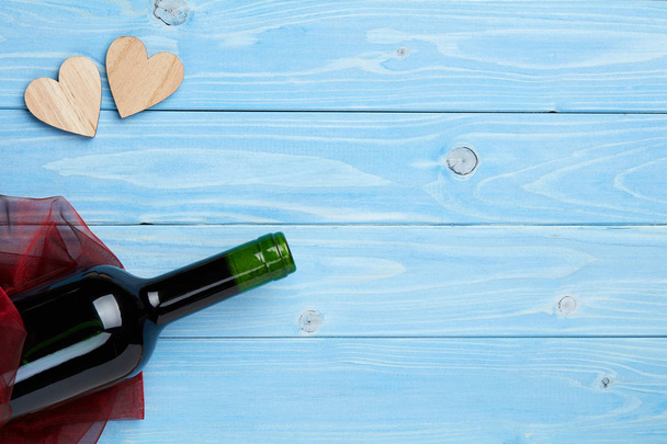 Вино та прикраси на синьому дерев'яному фоні
  - Фото, зображення