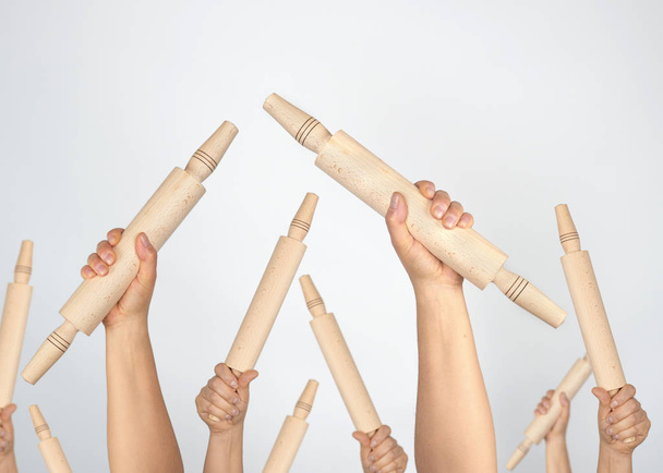 many hands raised up and holding kitchen wooden rolling pins - Photo, Image