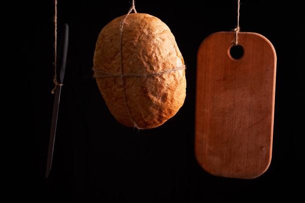 Pan fresco redondo colgado en una cuerda sobre un fondo negro. Copiar espacio
 - Foto, imagen