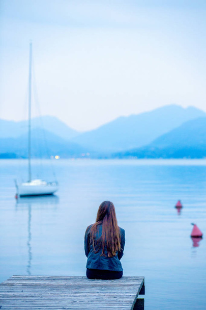 girl looks in the evening on the lake garda - Foto, afbeelding