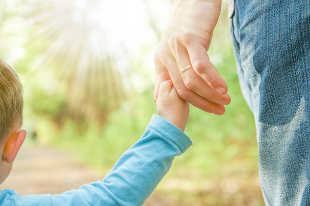the parent holding the child's hand with a happy background - Photo, Image