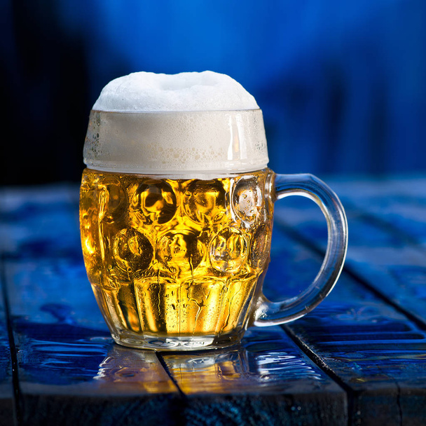 Glass of beer on the blue wooden background. - Zdjęcie, obraz