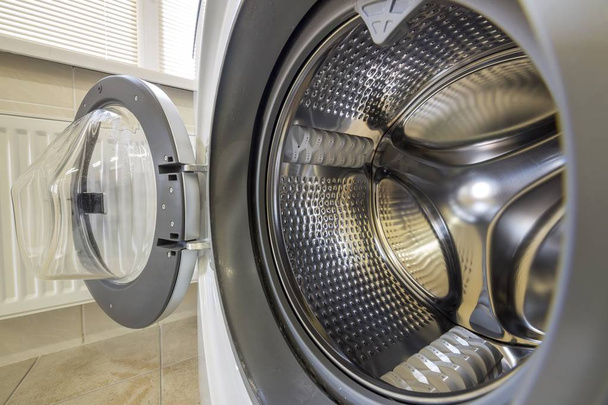 Крупный план современного интерьера стиральной машины с открытой какашкой
 - Фото, изображение