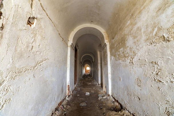Підвал старої фортеці, довгий вузький коридор зі склепінчастою стелею і брудною підлогою
. - Фото, зображення