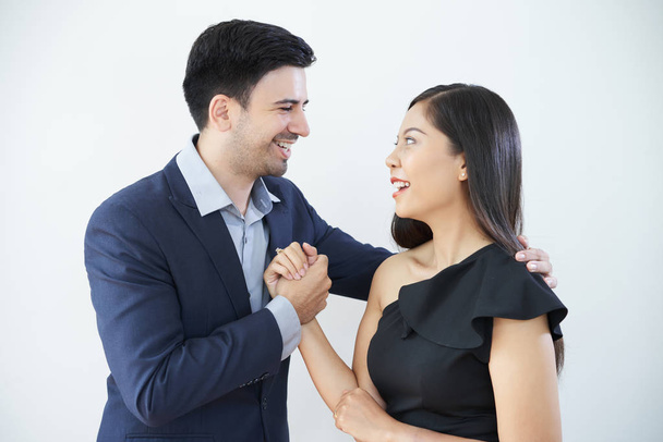Souriant jeune homme d'affaires félicitant la femme avec son succès et lui serrant la main alors qu'ils se tiennent sur fond blanc
 - Photo, image