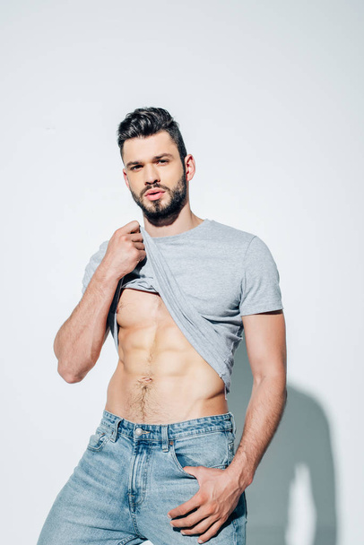 handsome bearded and muscular man looking at camera on white  - Φωτογραφία, εικόνα