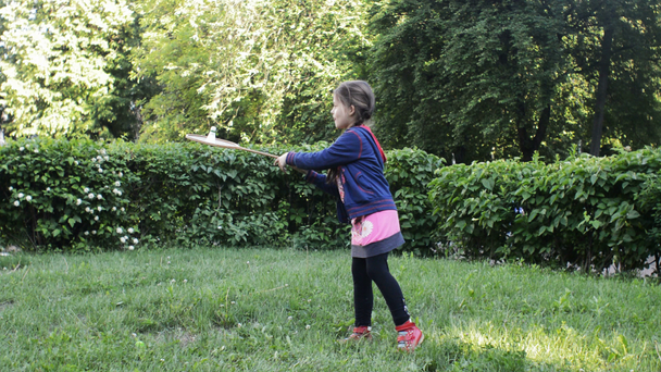 Ребенок на газоне играет в бадминтон
 - Кадры, видео