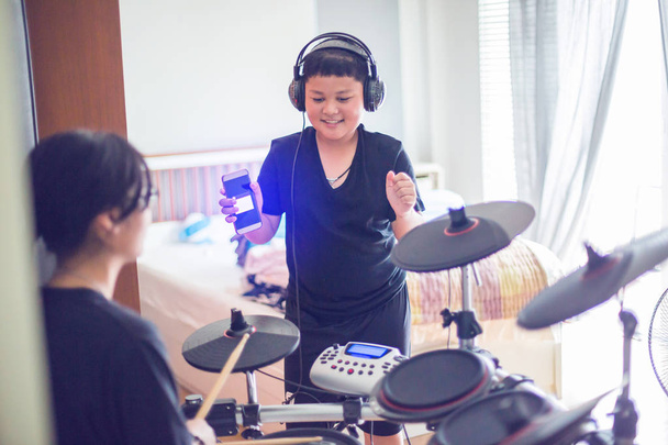 asiatische Mädchen und Jungen setzen schwarze T-Shirt und Kopfhörer lernen und p - Foto, Bild