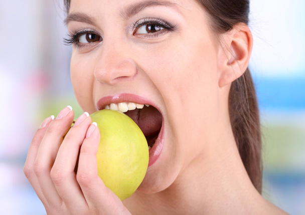 woman with apple on bright background - 写真・画像