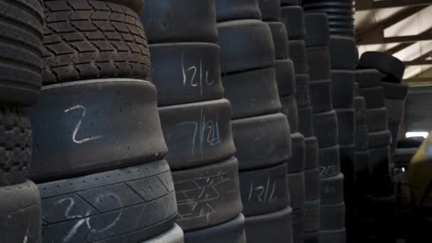 Bir garaj atölyesinde yığılmış ikinci el yarış arabası lastikleri - Video, Çekim